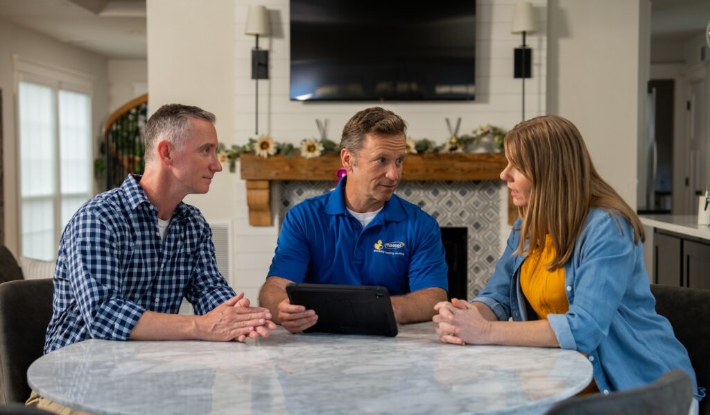 technician speaking with homeowners about backflow preventers and the importance of backflow prevention